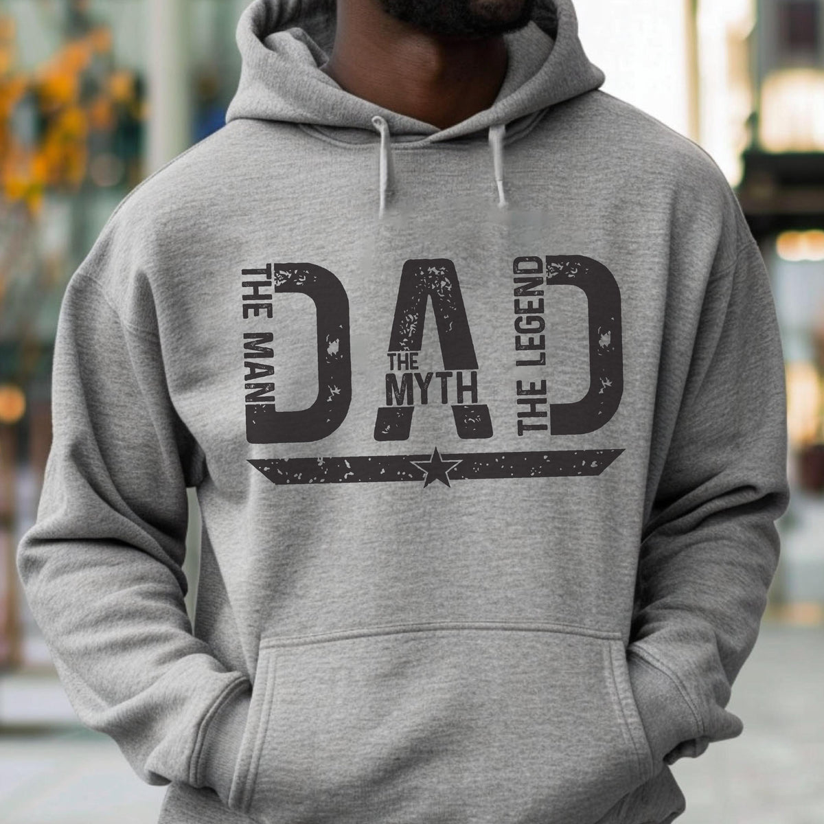 May include: Gray hoodie with the word "DAD" in large, distressed black letters. The words "THE MAN," "THE MYTH," and "THE LEGEND" are arranged around the word "DAD." A star graphic is below the word "DAD."