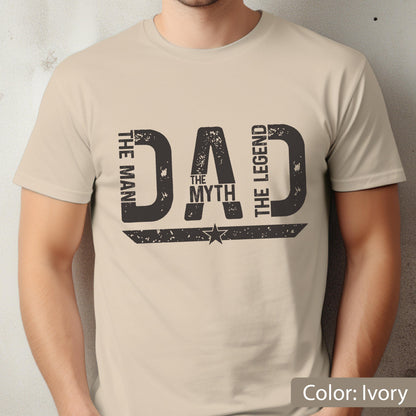 May include: Ivory-colored t-shirt with a distressed black graphic that reads "DAD" with "THE MAN", "THE MYTH", and "THE LEGEND" in a vertical arrangement. A star is centered below the word "DAD".