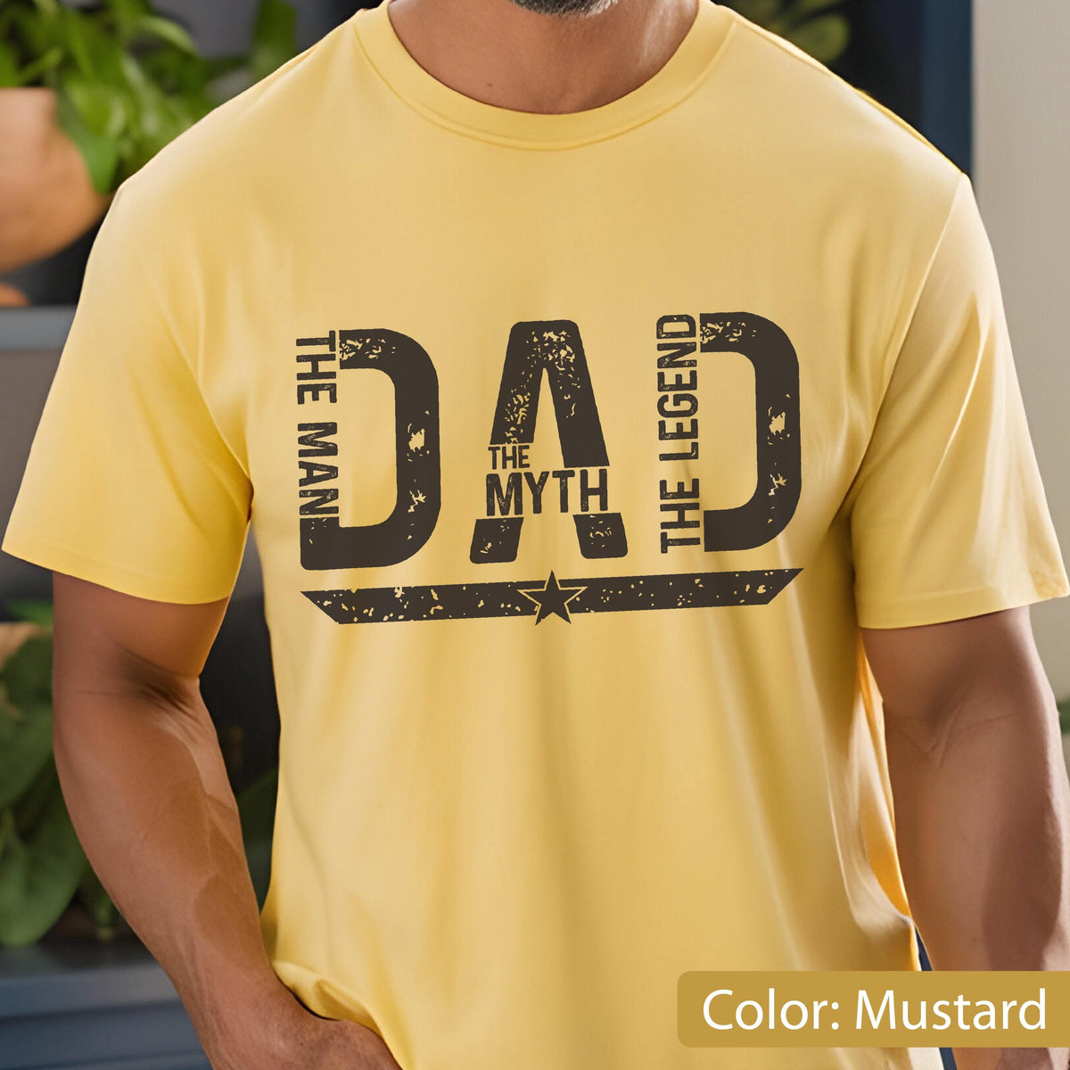 May include: Mustard yellow t-shirt with the word "DAD" in large, distressed black letters. The text "THE MAN THE MYTH THE LEGEND" is also printed on the shirt. A star graphic is below the word "DAD".