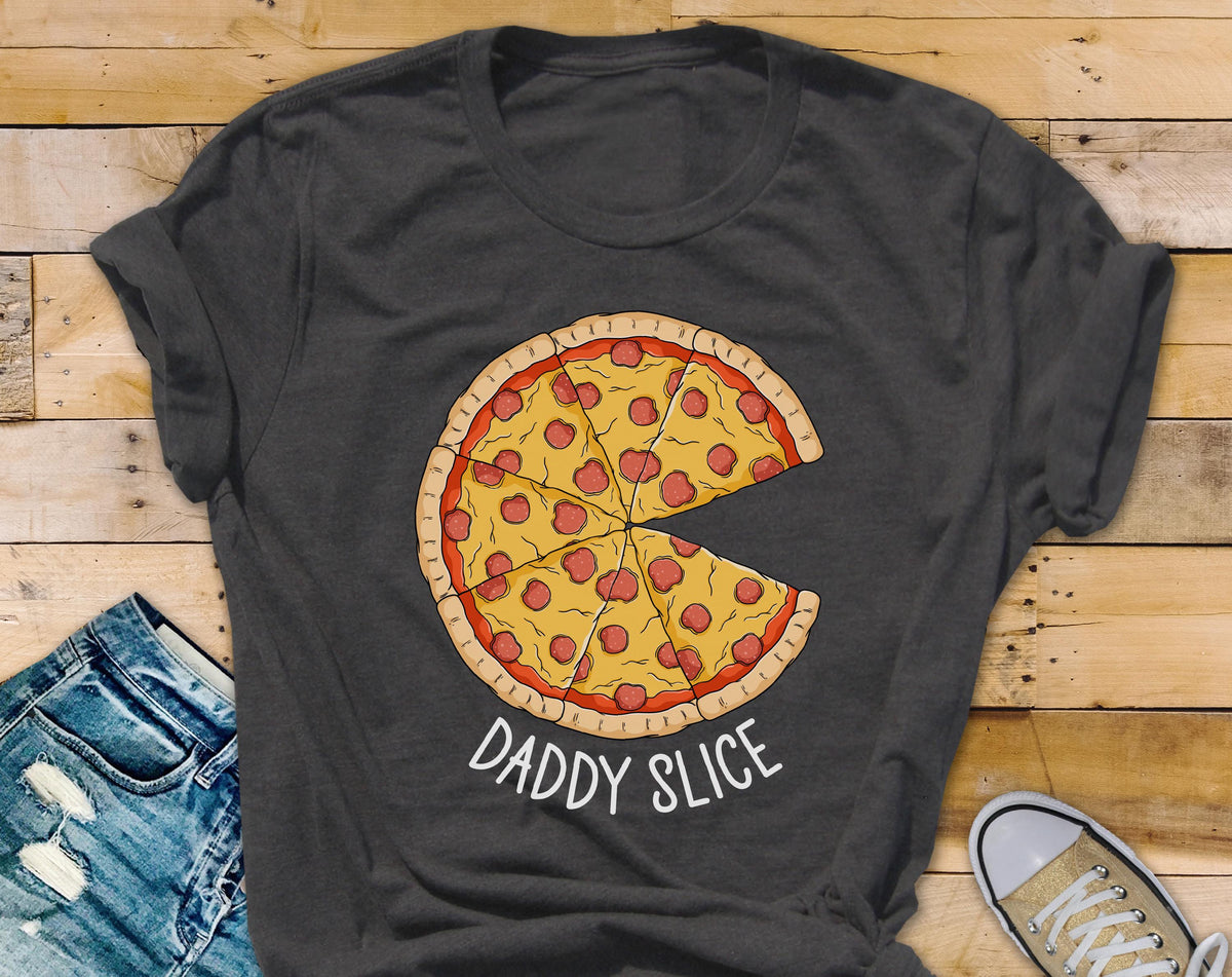 May include: Dark gray t-shirt featuring a pizza graphic with pepperoni and the text "DADDY SLICE" in white. The pizza has a yellow crust and red sauce. The shirt is made of a soft material.