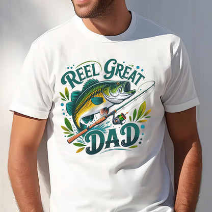 May include: White t-shirt with a graphic of a fish, fishing rod, and the words "Reel Great Dad" in green and teal. The fish is green, yellow, and white. The fishing rod is brown and the reel is green.