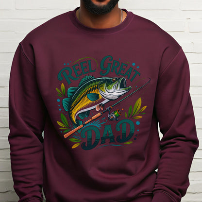 May include: Burgundy sweatshirt with a graphic of a fish, fishing rod, and the words "Reel Great Dad" in teal and green. The fish is yellow, green, and blue. The design includes decorative leaves.