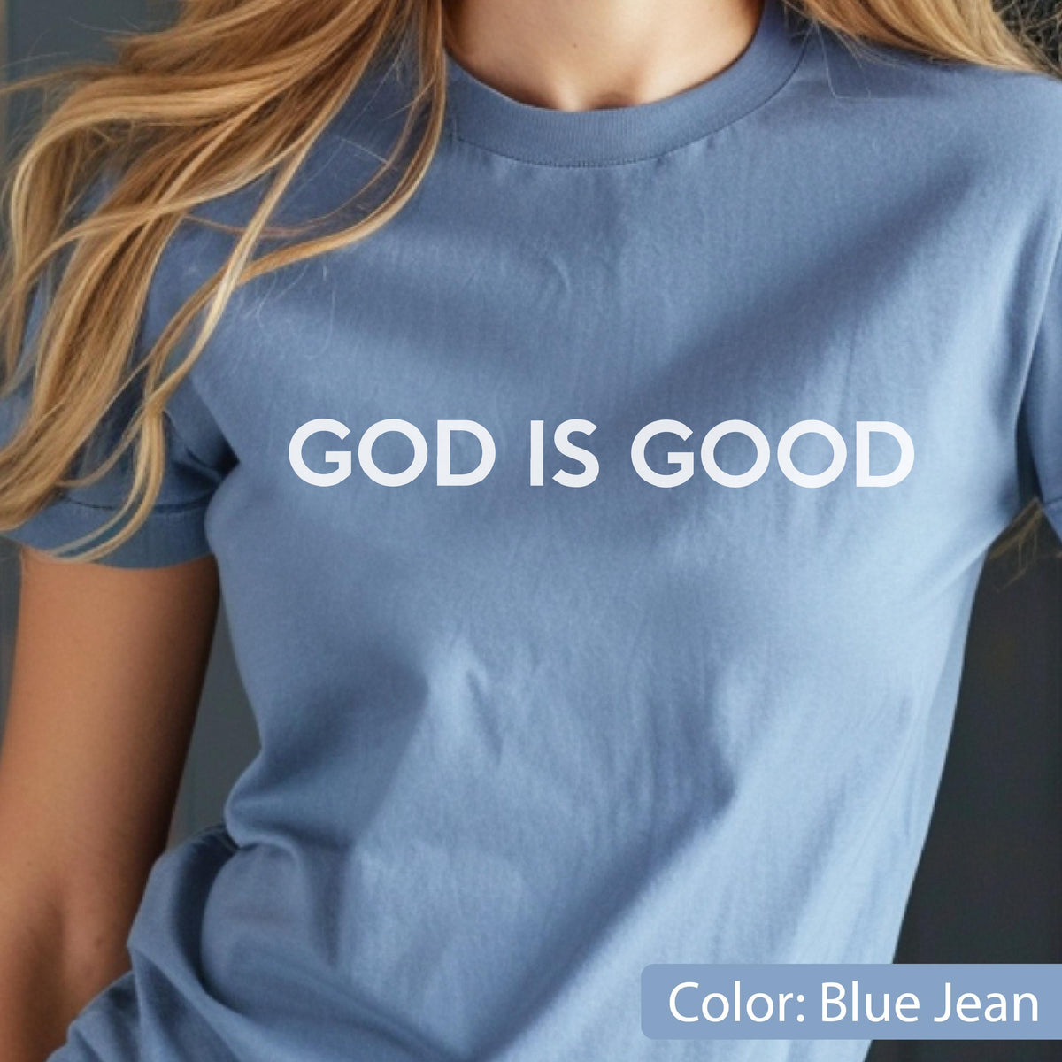 May include: A blue jean-colored t-shirt with the words "GOD IS GOOD" printed in white. The shirt has short sleeves and a crew neck. The color is described as blue jean.