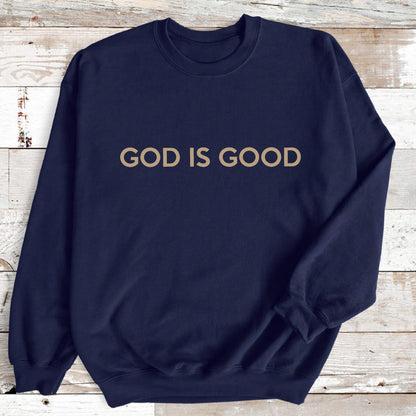 May include: Navy blue sweatshirt with the text "GOD IS GOOD" in a light brown color. The sweatshirt has a crew neck and long sleeves. The text is centered on the chest.