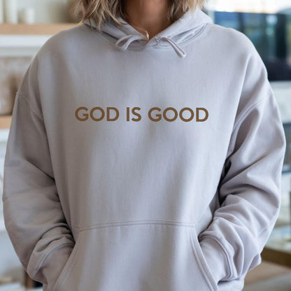 May include: A light gray hoodie with a front pocket and a drawstring hood. The words "GOD IS GOOD" are printed in brown across the chest. The hoodie is made of a soft material.