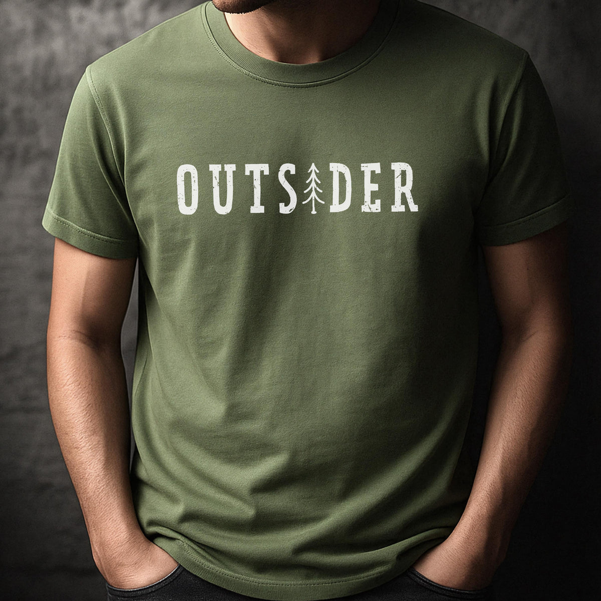 May include: An olive green short-sleeved crew neck t-shirt featuring the white text "OUTSIDER" printed across the chest. The letter "I" in the word is replaced by a stylized graphic of a tall, thin evergreen tree with a distressed texture.