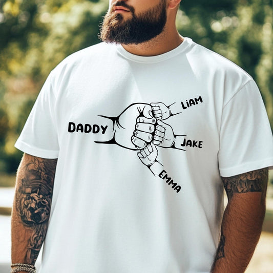 May include: A white t-shirt with a black graphic of five hands clasped together. The hands are labeled 'Daddy', 'Liam', 'Jake', and 'Emma'.