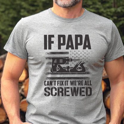 May include: A gray t-shirt with the text "IF PAPA CAN'T FIX IT WE'RE ALL SCREWED." The design includes a black graphic of a drill and a hand plane, with a star-filled flag design.