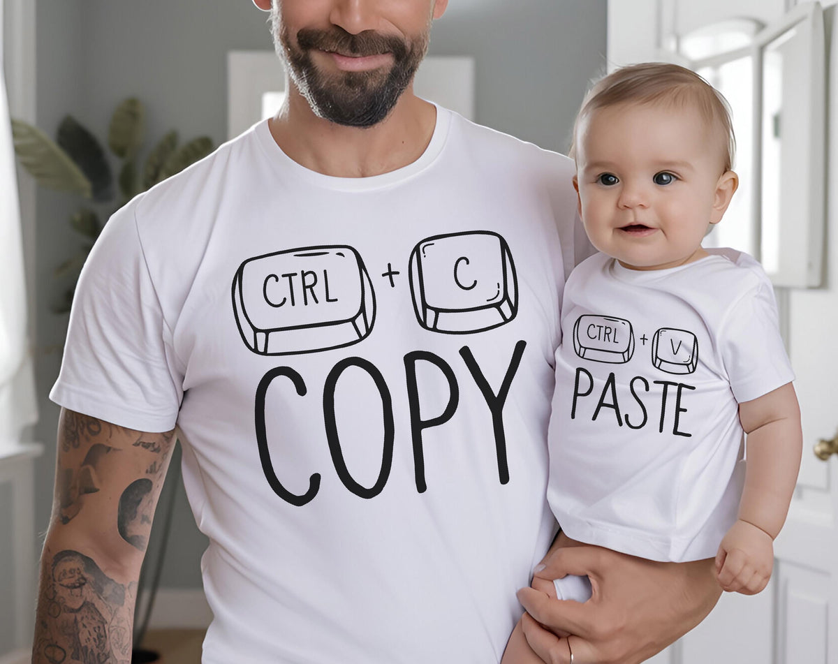 May include: White t-shirts with black text and graphics. One shirt says "CTRL + C COPY" and the other says "CTRL + V PASTE". The shirts are worn by a parent and a baby.