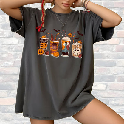 May include: Dark gray t-shirt featuring a Halloween-themed graphic. The design includes four stylized coffee cups with spooky decorations like pumpkins, bats, and a Jason Voorhees mask. The shirt is a relaxed fit.