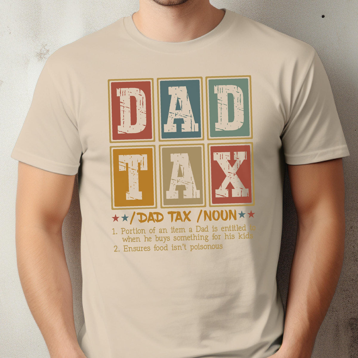 May include: Beige t-shirt with a retro design featuring the words "DAD TAX" in a grid of colorful boxes. Below, text defines "DAD TAX" as a noun, humorously describing a father's expenses for his kids.