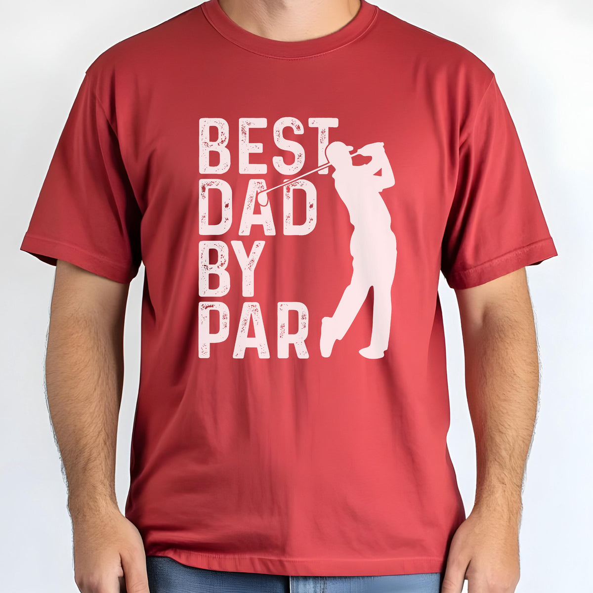 May include: A red short-sleeved t-shirt featuring a white graphic print. The design includes the text "BEST DAD BY PAR" in a distressed font, accompanied by a silhouette of a golfer swinging a club, positioned to the right of the text.