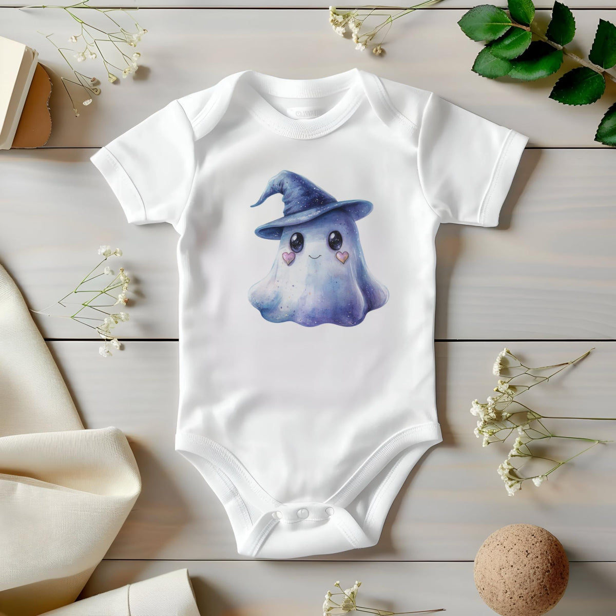 May include: White baby onesie featuring a watercolor illustration of a friendly ghost wearing a blue witch hat. The ghost has heart-shaped cheeks and a smiling expression. The onesie is made of soft material and has short sleeves.