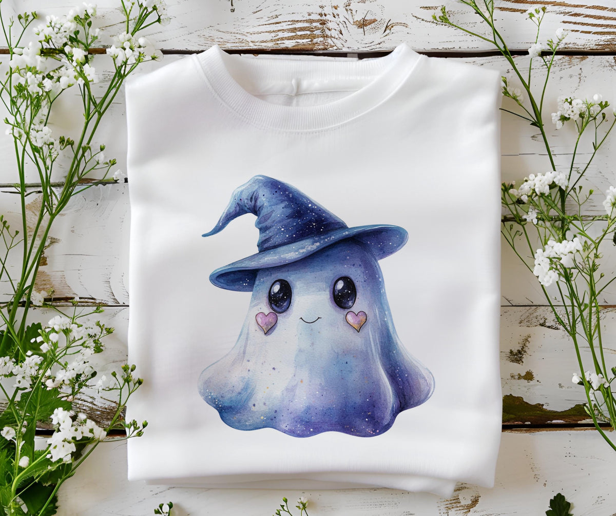 May include: White sweatshirt featuring a watercolor illustration of a friendly ghost wearing a blue witch hat. The ghost has large black eyes, a smiling mouth, and pink heart-shaped cheeks. The design is centered on the front of the folded garment.