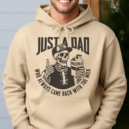 May include: Beige hoodie with a graphic featuring a skeleton wearing a baseball cap and jacket, holding a milk carton and giving a thumbs up. Text reads "JUST A DAD" and "WHO ALWAYS CAME BACK WITH THE MILK."