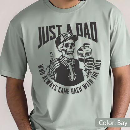 May include: A light green t-shirt with a graphic of a skeleton wearing a baseball cap and a letterman jacket, holding a milk carton and giving a thumbs up. The text reads "JUST A DAD WHO ALWAYS CAME BACK WITH THE MILK."