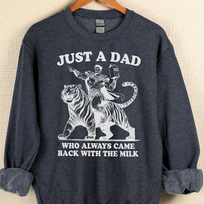 May include: Dark gray sweatshirt with the text "JUST A DAD WHO ALWAYS CAME BACK WITH THE MILK." A white graphic depicts a man riding a tiger, holding a milk carton. The sweatshirt has a crew neck and long sleeves.