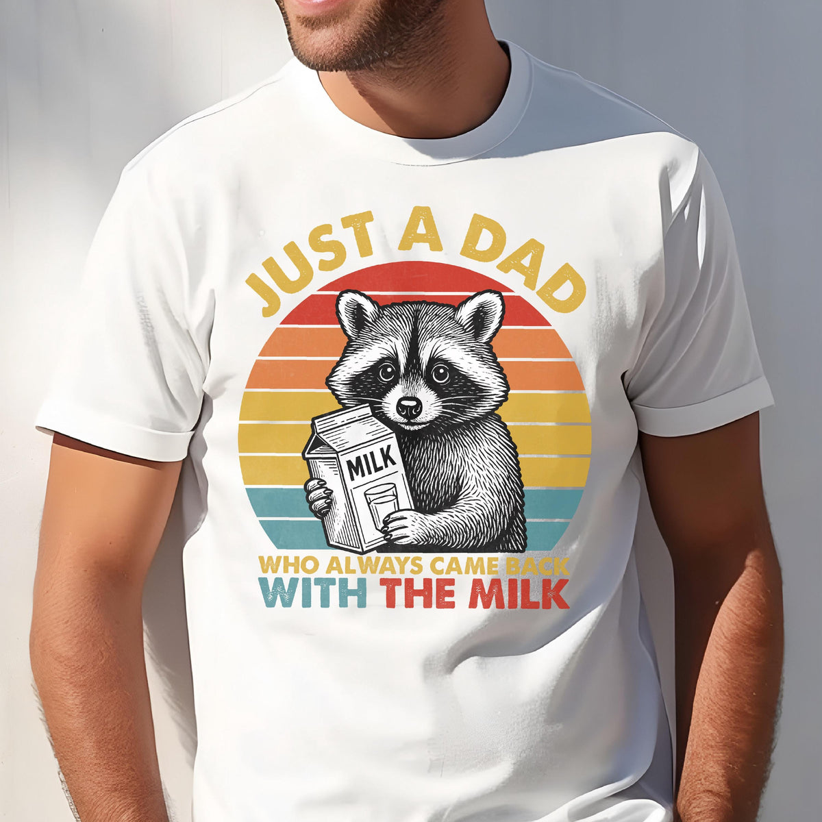 May include: White t-shirt featuring a raccoon holding a milk carton, set against a retro sunset design. Text reads "JUST A DAD WHO ALWAYS CAME BACK WITH THE MILK". A humorous and casual design.