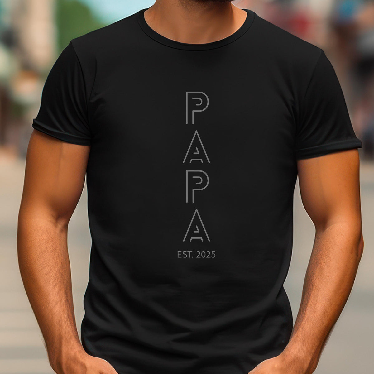 May include: Black t-shirt with the word "PAPA" in a vertical, outlined font. Below the word "PAPA" is the text "EST. 2025" in a smaller font. The shirt is a crew neck style.