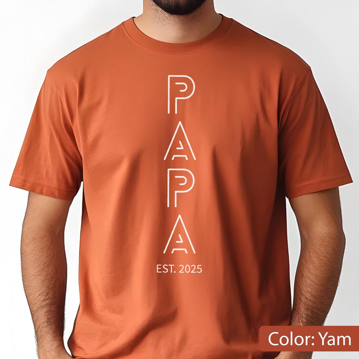 May include: A short-sleeved, yam-colored t-shirt with the word "PAPA" in white, vertically aligned. Below the word "PAPA" is the text "EST. 2025". The shirt is made of a soft material.