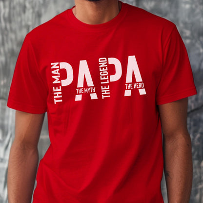 May include: A red t-shirt with the word "PAPA" in large white letters. The text is accompanied by the phrases "THE MAN", "THE MYTH", "THE LEGEND", and "THE HERO" in white, vertical text.