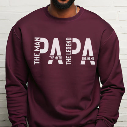 May include: A maroon sweatshirt with the word "PAPA" in large white letters. The text "THE MAN, THE MYTH, THE LEGEND, THE HERO" is printed vertically and horizontally around the word "PAPA".