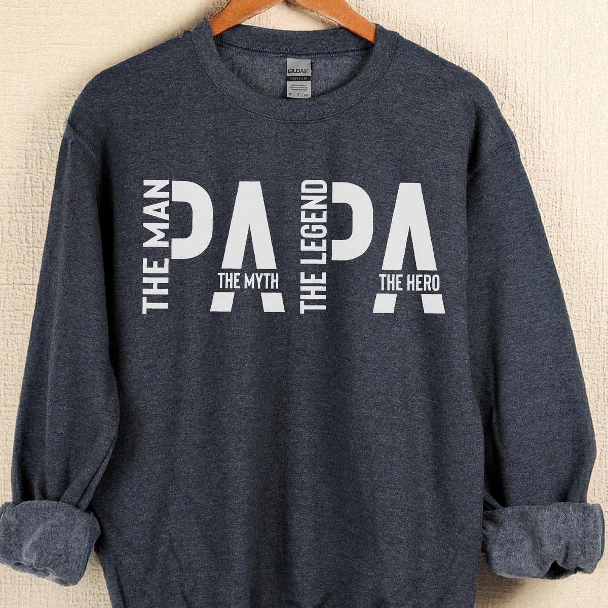 May include: A navy blue sweatshirt with the word "PAPA" in large white letters. The words "THE MAN", "THE MYTH", "THE LEGEND", and "THE HERO" are also printed on the sweatshirt.