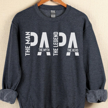 May include: A navy blue sweatshirt with the word "PAPA" in large white letters. The words "THE MAN", "THE MYTH", "THE LEGEND", and "THE HERO" are also printed on the sweatshirt.