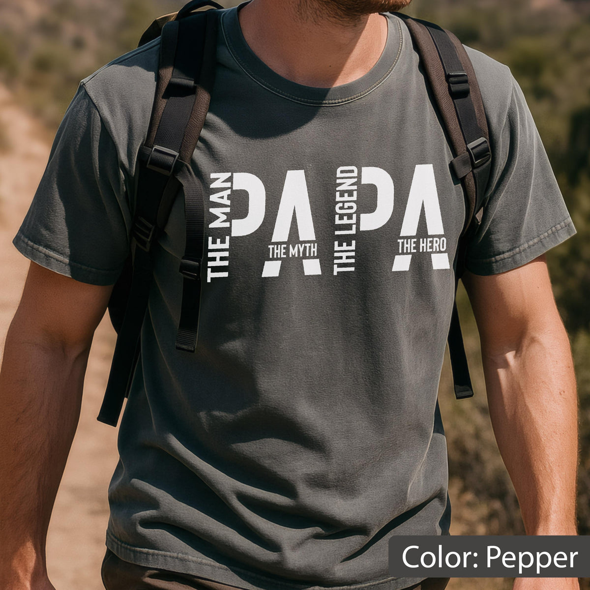May include: Pepper-colored t-shirt with the word "PAPA" in large white letters. The words "THE MAN", "THE MYTH", "THE LEGEND", and "THE HERO" are vertically stacked on the left and right sides of the word "PAPA".