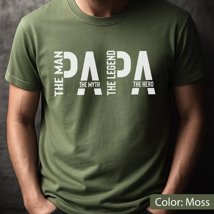 May include: A moss green t-shirt with the word "PAPA" in large white capital letters. The words "THE MAN", "THE MYTH", "THE LEGEND", and "THE HERO" are also printed on the shirt in white. The text "Color: Moss" is at the bottom.