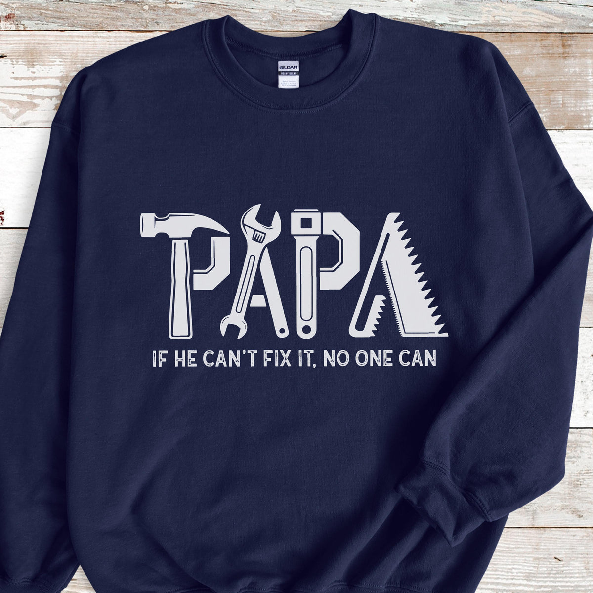 May include: Navy blue sweatshirt with the word "PAPA" in white, designed with tool graphics. The text "IF HE CAN'T FIX IT, NO ONE CAN" is below the word "PAPA".