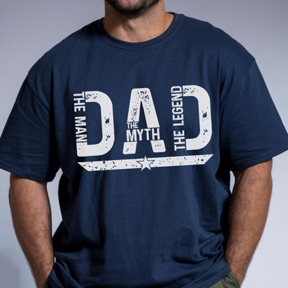 May include: Navy blue t-shirt with the text "DAD THE MAN THE MYTH THE LEGEND" in distressed white lettering. A star graphic is below the word "MYTH". The shirt is a casual style.