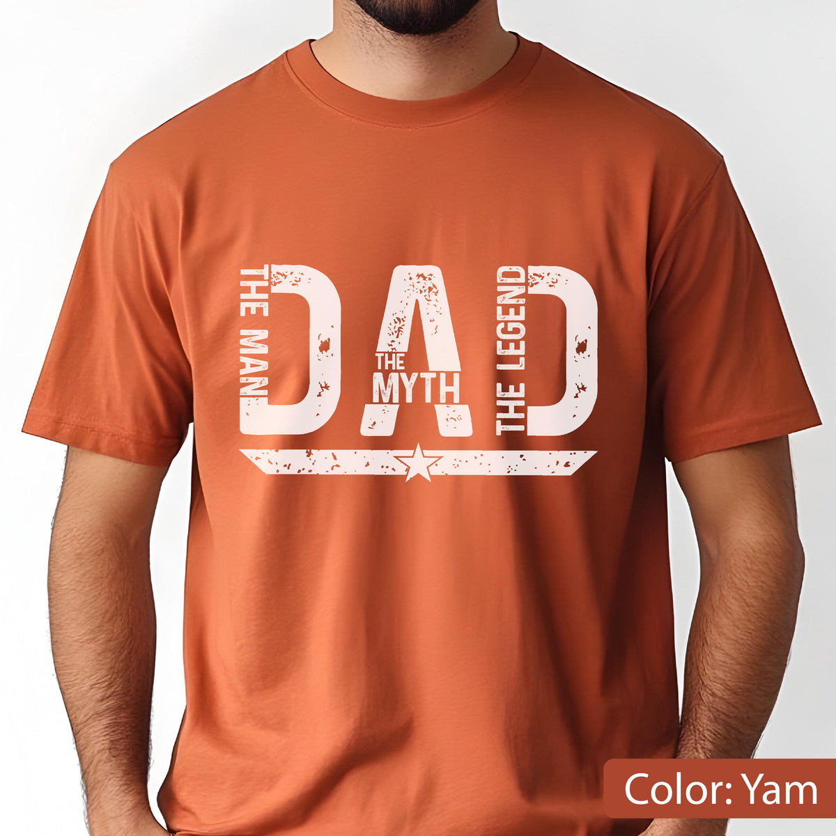 May include: A yam-colored t-shirt with the word "DAD" in large, distressed white letters. The text "THE MAN", "THE MYTH", and "THE LEGEND" are arranged around the word "DAD". A star and a horizontal line are below the word "DAD".