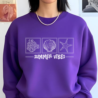 May include: A purple sweatshirt with a white graphic featuring a coral, seashell, and starfish design. The text "SUMMER VIBES" is printed below the images. The sweatshirt has a crew neck.