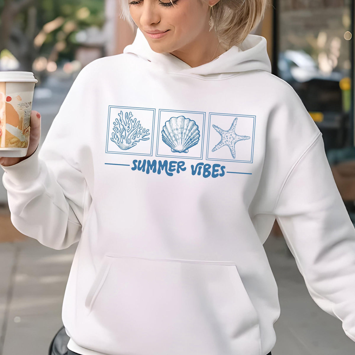 May include: White hoodie with a front pocket and a drawstring hood. The design features three blue square illustrations of coral, a seashell, and a starfish, with the words "SUMMER VIBES" underneath.
