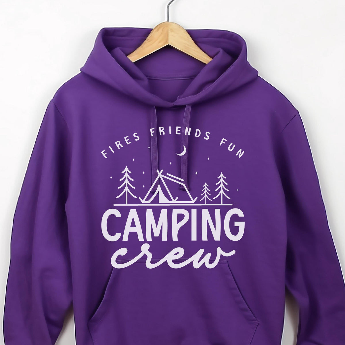 May include: A purple hooded sweatshirt with the words "Fires Friends Fun" and "Camping Crew" in white. The design includes a tent, trees, a crescent moon, and stars. The sweatshirt is hanging on a wooden hanger.