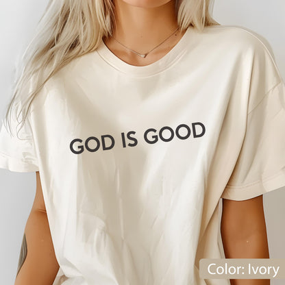 May include: Ivory-colored t-shirt with the phrase "GOD IS GOOD" printed in black. The shirt has a classic crew neck and short sleeves. The color is ivory.