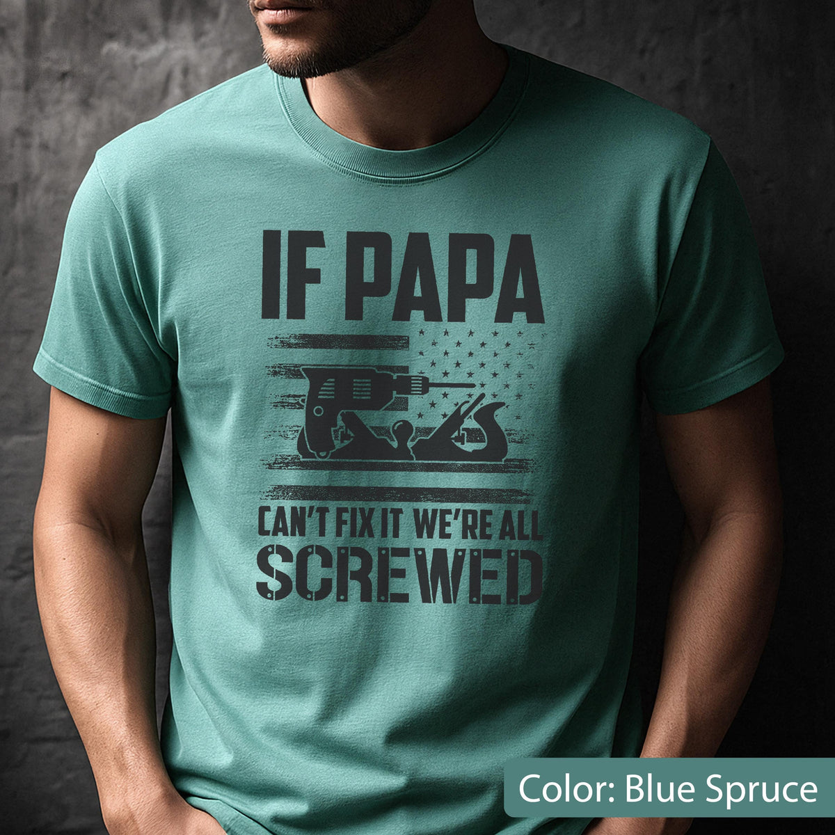 May include: Blue spruce t-shirt with the text "IF PAPA CAN'T FIX IT WE'RE ALL SCREWED." The graphic includes a drill and a hand plane, with an American flag design in the background. The shirt is a crew neck.