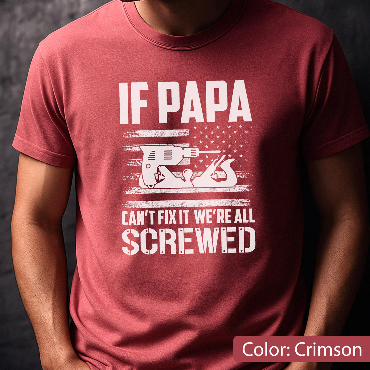 May include: Crimson-colored t-shirt with the text "IF PAPA CAN'T FIX IT WE'RE ALL SCREWED" in white. The design includes a drill and a hand plane over a stylized American flag.