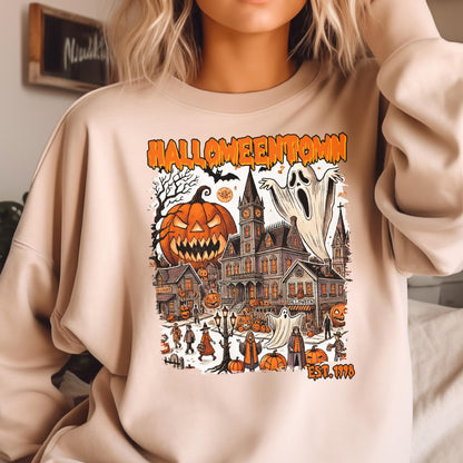 May include: A beige crewneck sweatshirt featuring a graphic print with the text HALLOWEENTOWN EST. 1998. The illustration depicts a spooky town scene with a large jack-o'-lantern, ghosts, a clock tower, and various figures in a Halloween setting.