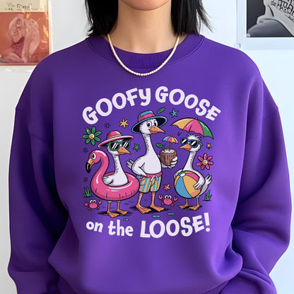 May include: A purple sweatshirt with the phrase "GOOFY GOOSE on the LOOSE!" and a graphic of three cartoon geese in sunglasses and beach attire. One goose is in a flamingo float, another holds a coconut drink, and the third has a beach ball.