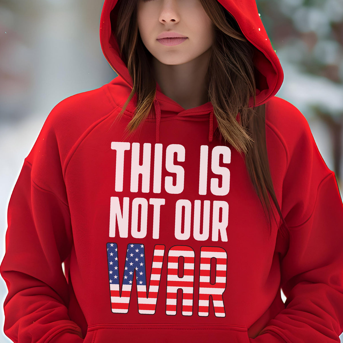 May include: A red hooded sweatshirt with the text "THIS IS NOT OUR WAR" in white. The word "WAR" features a design incorporating the American flag. The sweatshirt is a solid red color.