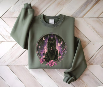May include: Olive green sweatshirt featuring a detailed illustration of a black cat with glowing eyes, set within a circular frame. The cat is surrounded by a celestial background with pink roses at the base. The sweatshirt has long sleeves.