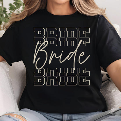 May include: Black t-shirt with the word "Bride" in a cursive font, overlaid on a stacked block letter design that also spells "Bride". The text is in a light beige color.
