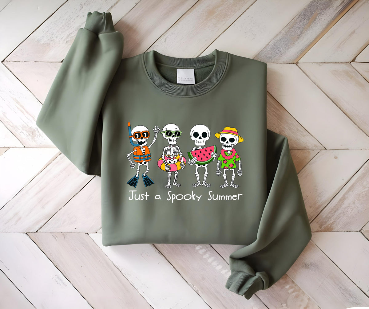 May include: Olive green sweatshirt with a graphic of four skeleton characters in summer attire. One wears a snorkel, another sunglasses, a third holds watermelon, and the last wears a straw hat. Text reads "Just a Spooky Summer."