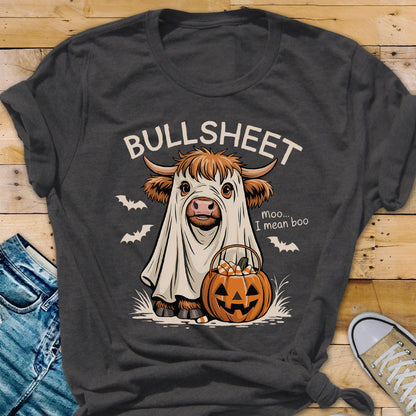 May include: Dark gray t-shirt with a Halloween-themed graphic. The design features a cow in a ghost costume, a jack-o'-lantern, and the text "BULLSHEET". The cow is holding a pumpkin basket with candy corn.