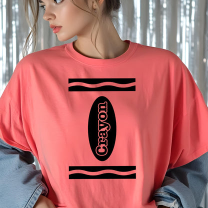 May include: A coral pink short-sleeved t-shirt featuring a black graphic design on the chest. The design consists of two horizontal wavy lines and a central black oval containing the word Crayon written in a bold, stylized black font.