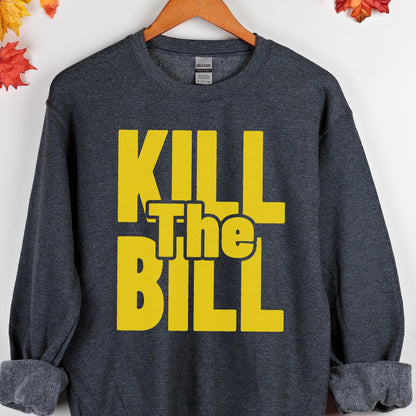May include: Dark gray sweatshirt with the text "KILL The BILL" in bright yellow block letters. The sweatshirt is hanging on a wooden hanger.