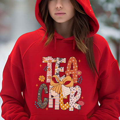 May include: A red hooded sweatshirt with the word "TEACHER" in a colorful floral and patterned design. The design includes a pencil, a bow, and floral accents. The sweatshirt is made of a soft material.