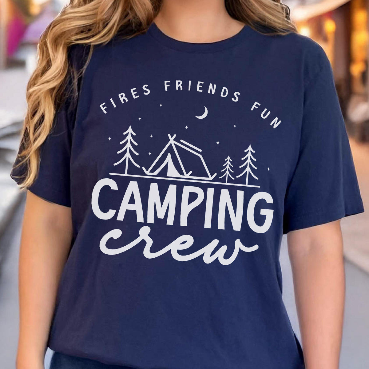 May include: Navy blue t-shirt with white text and graphic. The text reads "Fires Friends Fun" above a tent and trees graphic, with the words "Camping Crew" below. The shirt is a casual style.